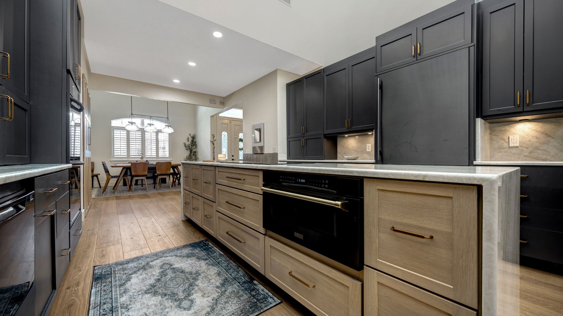 Modern kitchen with black cabinets and brown cabinets on the island
