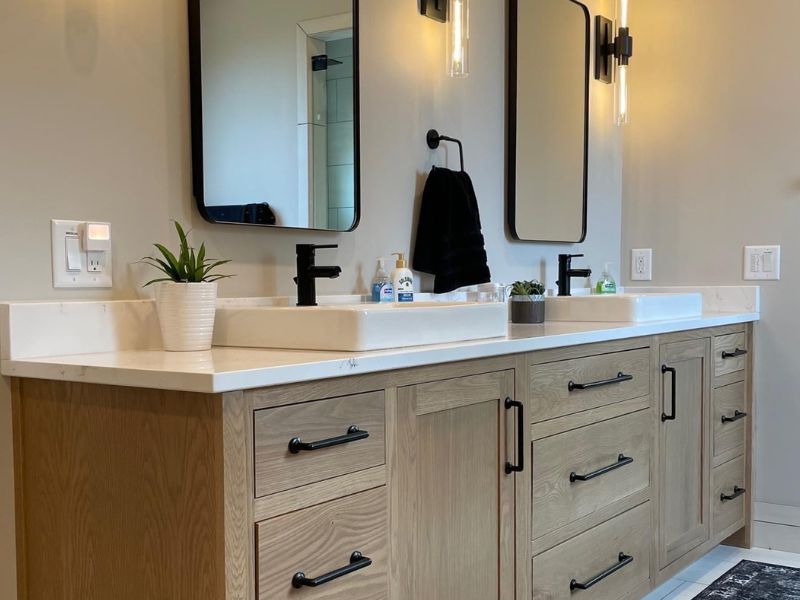 Modern Bathroom with Dark Gray Vanity and Pendant Lighting Modern bathroom with dark gray vanity cabinets, white countertops, a large mirror, sleek fixtures, and warm pendant lighting creating a stylish and inviting atmosphere.