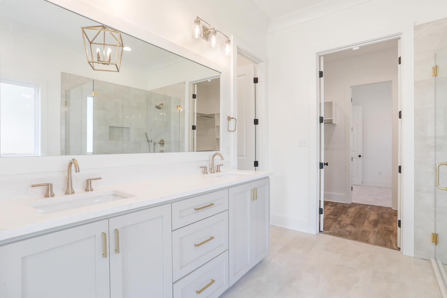 White bathroom cabinetry with gold details